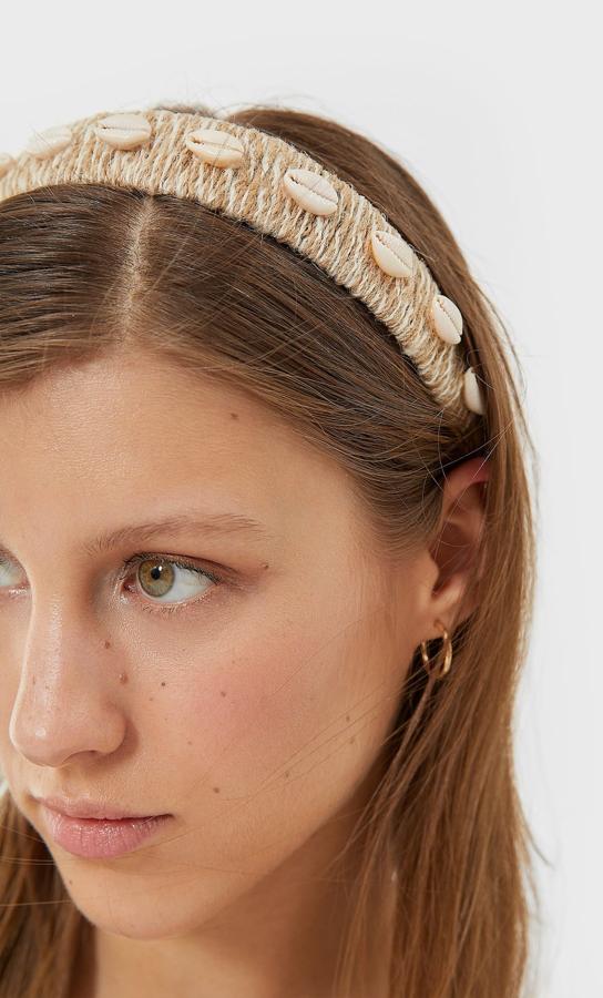Entre los diseños más veraniegos hemos encontrado este en tejido de rafia y conchas repartidas por toda la diadema. Es de Stradivarius y cuesta 7,99 euros.