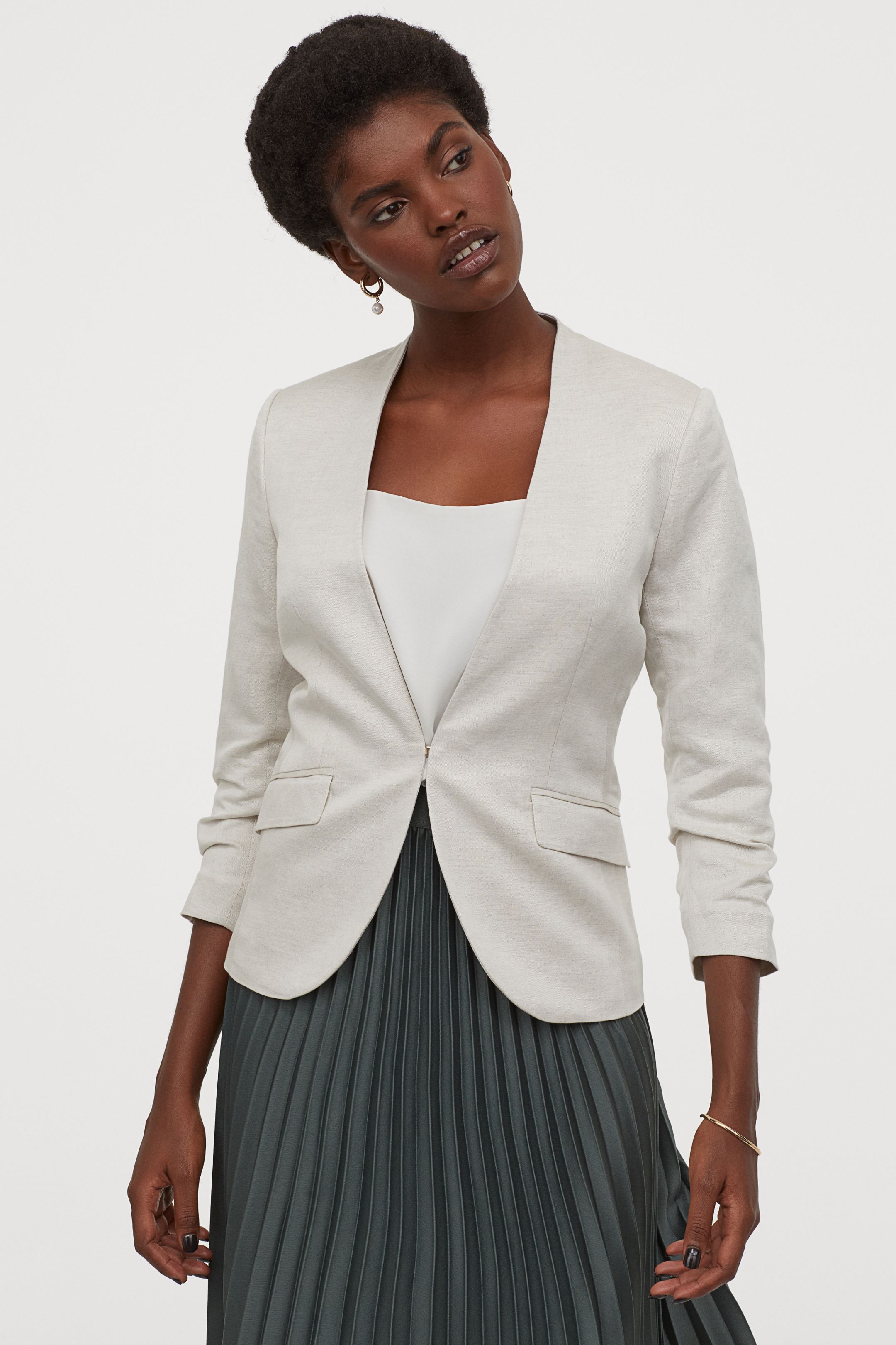 Blazer clásica de oficina con diseño entalladado, cierre oculto y puños drapeados. (39,99 euros).