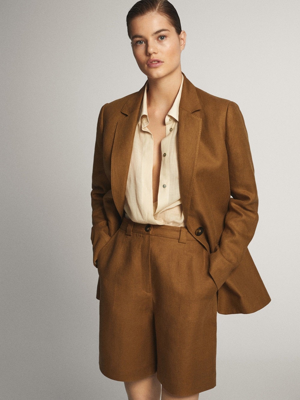 Americana de lino de Massimo Dutti en tono toffe de corte recto y bolsillos delanteros. (129 euros).