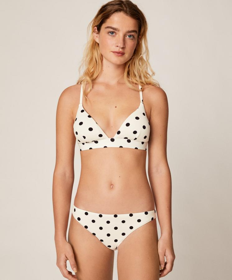 De tejido con estructura y estampado de topos negros sobre fondo blanco, este bikini está formado por sujetador (17,99 euros) triangular y braguita (12,99 euros) clásica a juego.