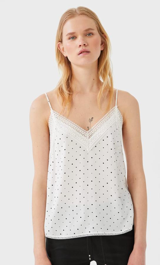 Stradivarius también nos propone este top lencero en color blanco con pequeños topos en negro. De tirante fino y detalle de puntilla, tiene un precio de 12,99 euros.