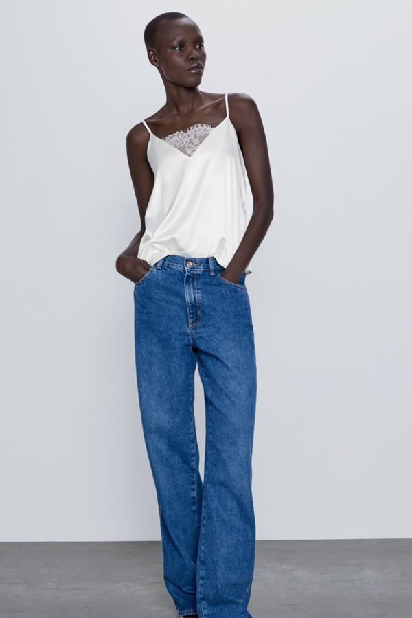 En color blanco roto, este top satinado con escote de pico y detalle de encaje es de Zara y está disponible en las tallas S, M y L. Tiene un precio de 15,95 euros.