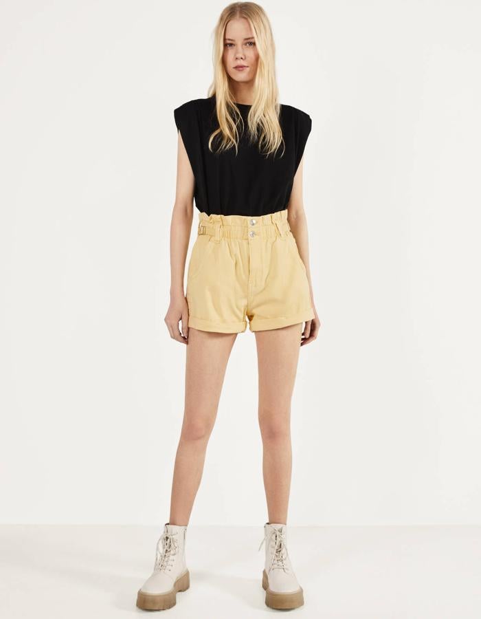 En color amarillo, estos pantalones cortos de Bershka cuentan con cintura elástica y trabillas. Tienen un precio de 15,99 euros.