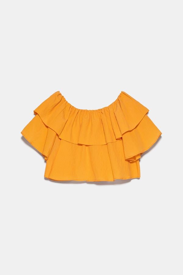 Este top de volantes en color calabaza y escote recto será el protagonista de muchos de tus estilismos esta temporada. Tiene un precio de 22,95 euros.