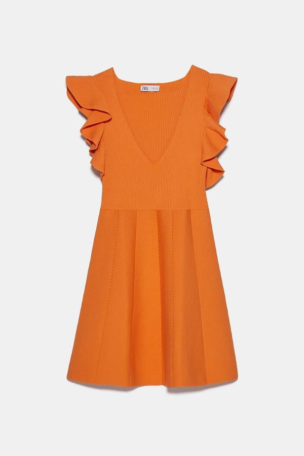 En color naranja, este vestido de punto cuenta con escote de pico y manga sisa. Con detalle de volantes, tiene un precio de 29,95 euros.