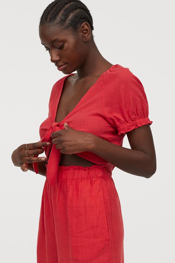 Con mangas abullonadas y en color rojo, esta blusa corta con escote de pico cuenta con lazada cosida en la parte delantera y tiene un precio de 19,99 euros.