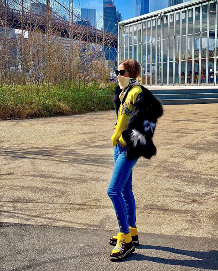 Añadiendo un toque ácido de pinceladas amarillas a sus botas de montañero y su jersey bajo un abrigo de pelo.