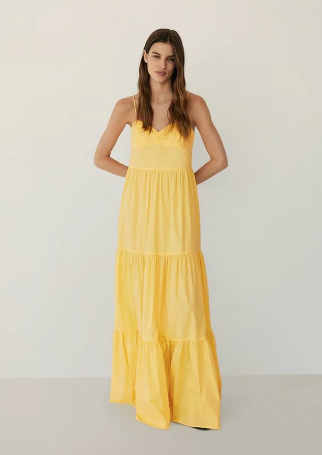 Este vestido de Mango confeccionado en popelín de algodón huele a verano gracias a su bonito diseño acampanado de volantes y su llamativo color amarillo pastel. Cuesta 49,99 euros y está disponible entre las tallas XS y XL.
