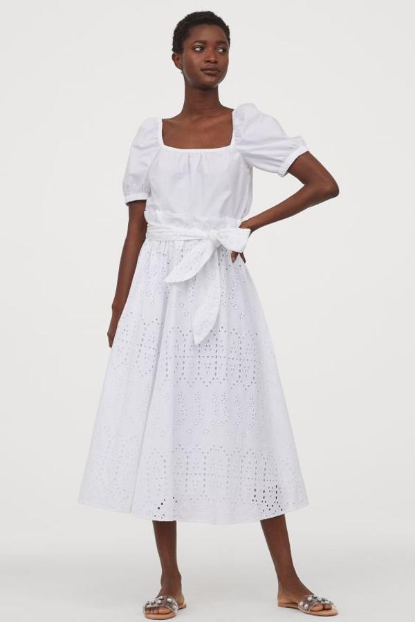 En H&M hemos encontrado este bonito diseño acampanado con bordado inglés. De talle alto, con cintura elástica ancha paperbag con ribete de volante y cinturón a tono extraíble. Cuesta 39,99 euros y está disponible entre las tallas S y XL.