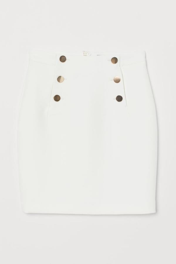 La propuesta más corta de esta selección es esta falda de H&M con botones decorativos delante en color dorado. Llega hasta la rodilla y tiene el cierre con cremallera oculta detrás. Cuesta 29,99 euros y está disponible entre las tallas 40 y 50, aunque todas se están agotando.