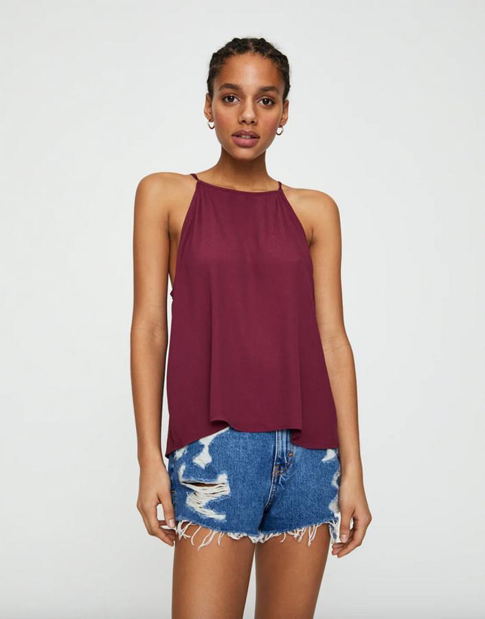 De corte amplio y tiras finas en el cuello, este bonito top de Pull&Bear tiene un precio de 9,99 euros y solo queda en las tallas M y L.