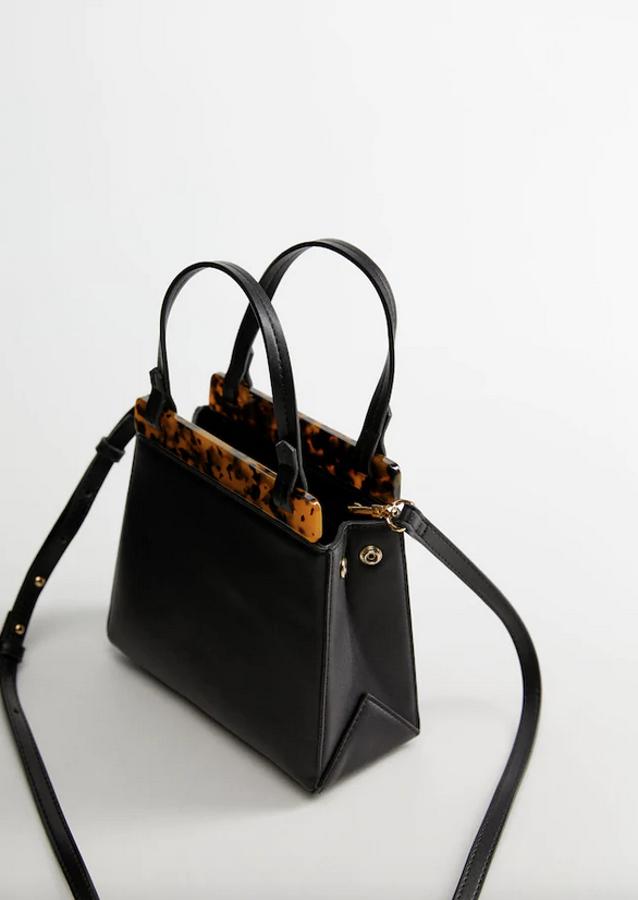 En color negro con un bonito detalle de efecto carey en ambos lados, este bolso mini de diseño rígido con asas cortas y largas, esta última desmontable, es de Mango. Está rebajado y de 39,99 euros, ahora podemos comprarlo por 22,99 euros.