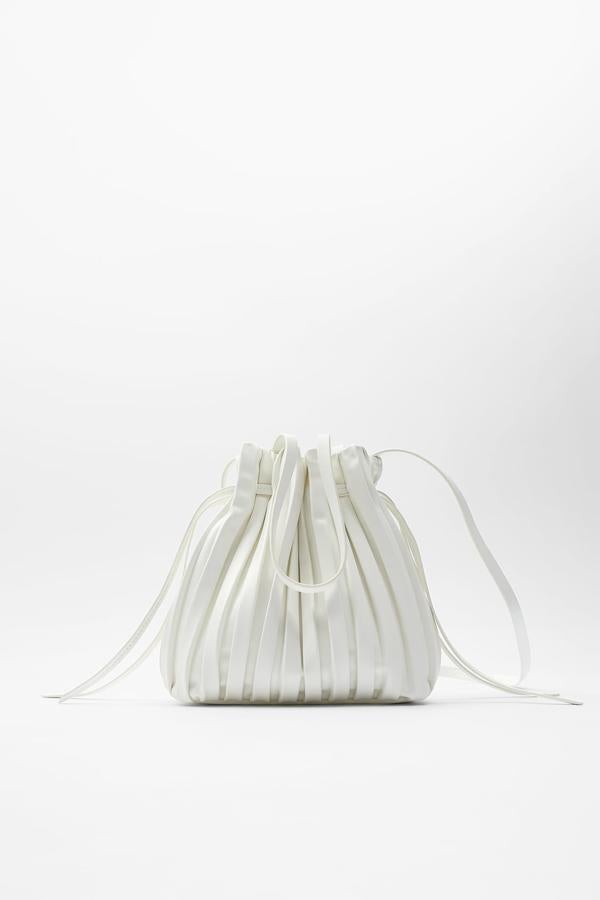 En formato mini saca en color blanco, este bolso de Zara viene con cuerpo plisado con detalle fruncido en la parte superior. Con asas de hombro y asa larga ajustable, tiene un precio de 19,95 euros.