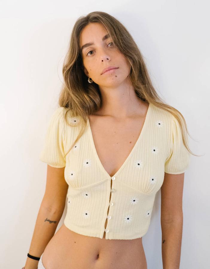 Las margaritas también han llegado a las camisetas y en Bershka han invertido los colores para llevarlas a esta prenda cropped. Pétalos blancos y centro negro sobre fondo amarillo pastel bordadas en esta camiseta que también está disponible en rosa. Tiene un precio de 15,99 euros y está disponible entre las tallas XS y L.