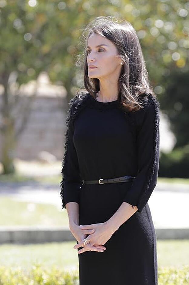 La reina Letizia ha elegido un vestido negro con detalles de flecos y cinturón para el minuto de silencio a las víctimas del Covid-19. Lo ha adornado con un cinturón y ha elegido unas bailarinas planas negras como calzado.