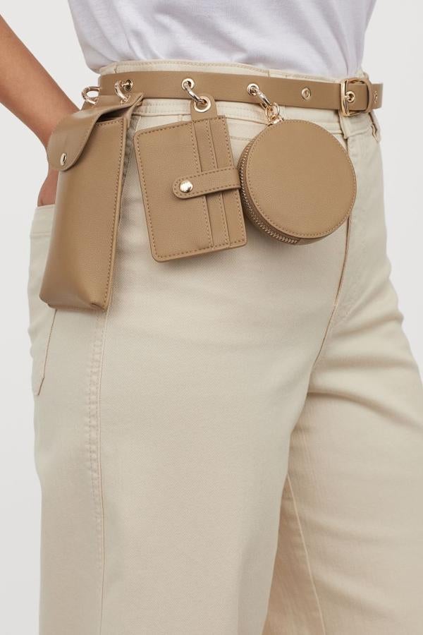 Funda de Smartphone, tarjetero y cartera de mano mini para este cinturón fino en piel sintética de H&M que gracias a sus múltiples anillas de metal nos permite cambiar de ubicación los accesorios o prescindir de aquel que no necesitemos. En color verde aceituna, está disponible entre las tallas XXS y XL y tiene un precio de 19,99 euros.