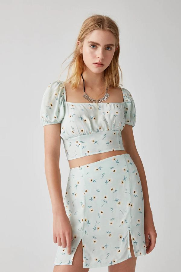 Esta minifalda aguamarina con estampado de flores pequeñas cuenta con aberturas laterales y tiene un precio de 15,99 euros. A juego encontramos el top (15,99 euros) con detalle de cazuelas en el pecho.