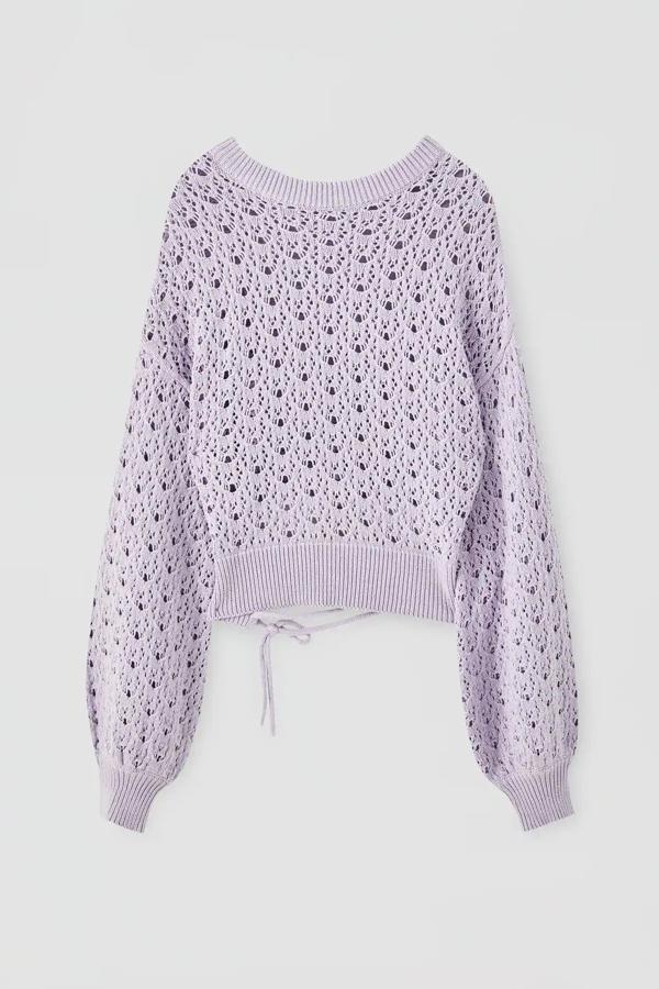 En color lila, este jersey fino con diseño de calados y manga abullonada tiene un precio de 22,99 euros. Confeccionado en 100& algodón, tiene el cuello redondo y detalle en el bajo.