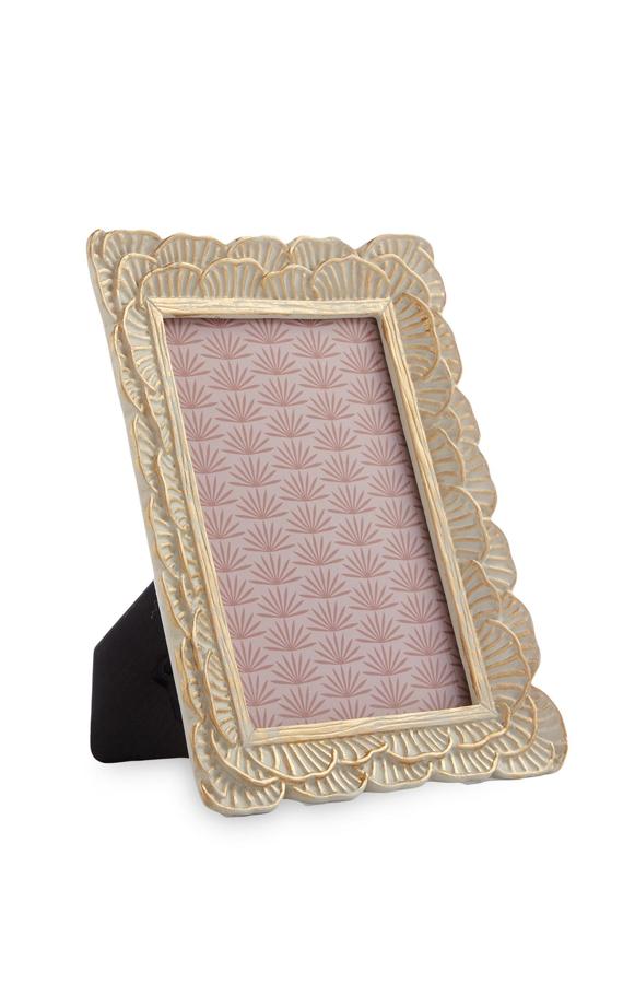 Marco de fotos dorado con pétalos grabados. Tiene un precio de 4 euros.