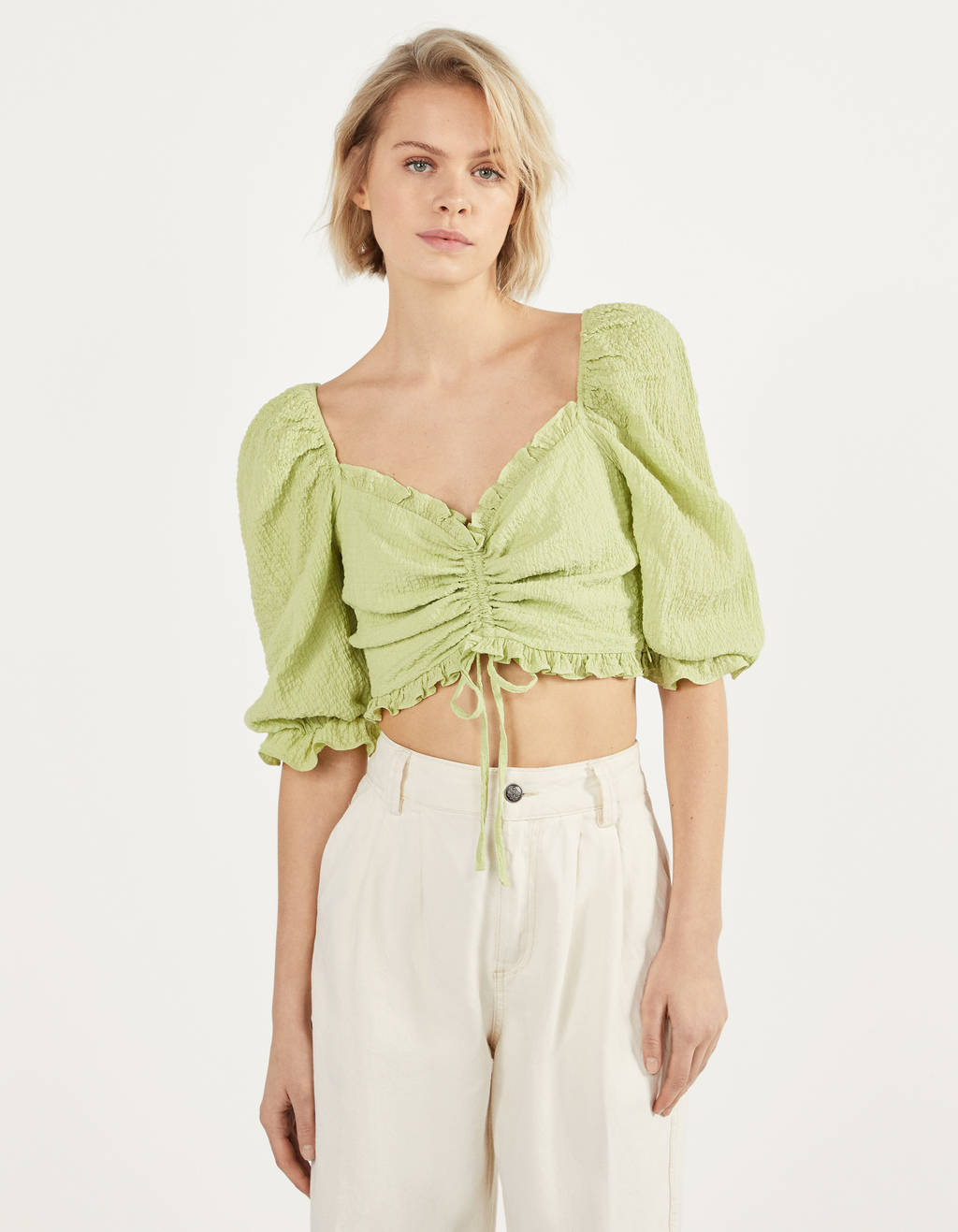 Con esta blusa en verde pistacho de Bershka conseguirás un escote bonito además de iluminar tu bronceado este verano y lucir tipazo gracias al fruncido central ajustable.  (17,99 euros) .