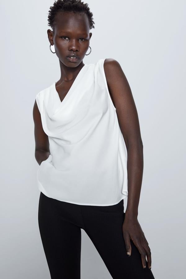 Blusa blanca sin mangas con escote fluido, de Zara (19,95 euros).