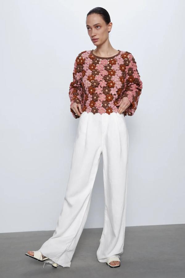En tonos marrones y rosas, este jersey de crochet de manga larga con cuello redondo es de Zara. Con tejido en forma de flor, tiene un precio de 39,95 euros.
