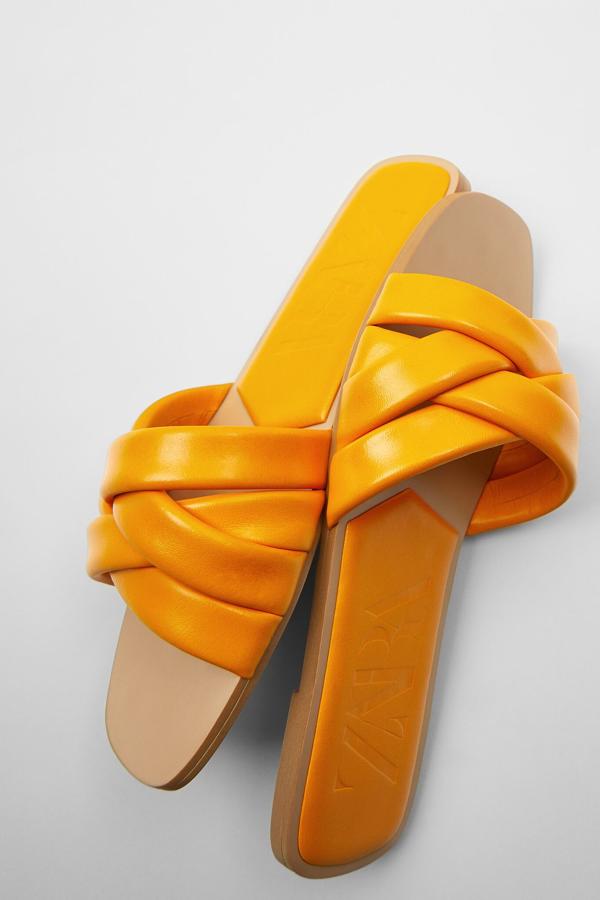 En color naranja, beige o violeta, estas sandalias planas con tiras acolchadas en la parte delantera son de Zara y tienen un precio de 29,95 euros.