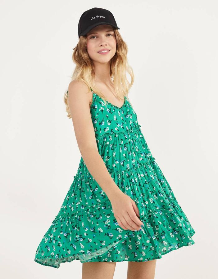 Con tirantes finos y escote en V, este vestido verde con estampado de flores blancas tiene volumen en toda la prenda y es de Bershka. Cuesta 19,99 euros y está disponible entre las tallas XS y L.
