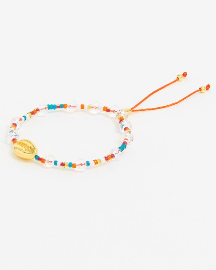 Pulsera de cuerda con cuentas multicolores tranparentes y una concha dorada, de Bimba y Lola (25 €).