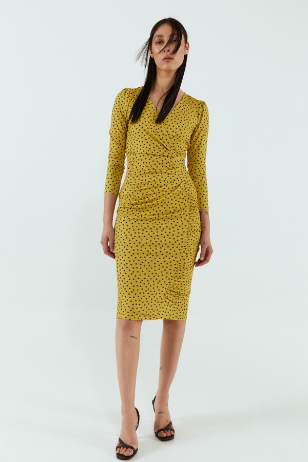 Vestido ajustado con fruncidos, en un color amarillo mostaza súper favorecedor (19,99 euros).