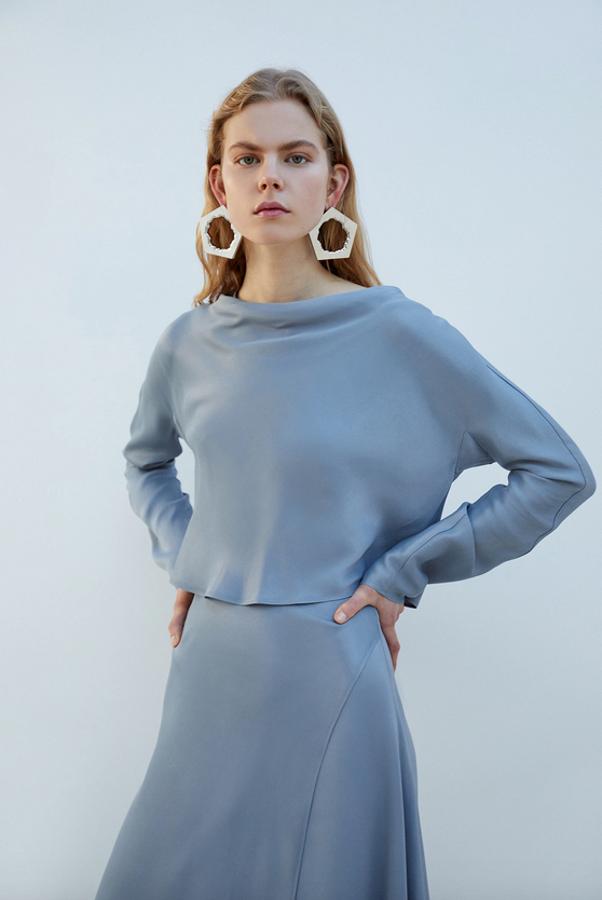 Este cuerpo de manga larga drapeado de Sfera en color gris azulado nos parece perfecto para colarse en nuestros estilismos otoñales más elegantes. De 35,99 euros ha pasado a costar 19,99 euros y está disponible en las tallas S, M y L.