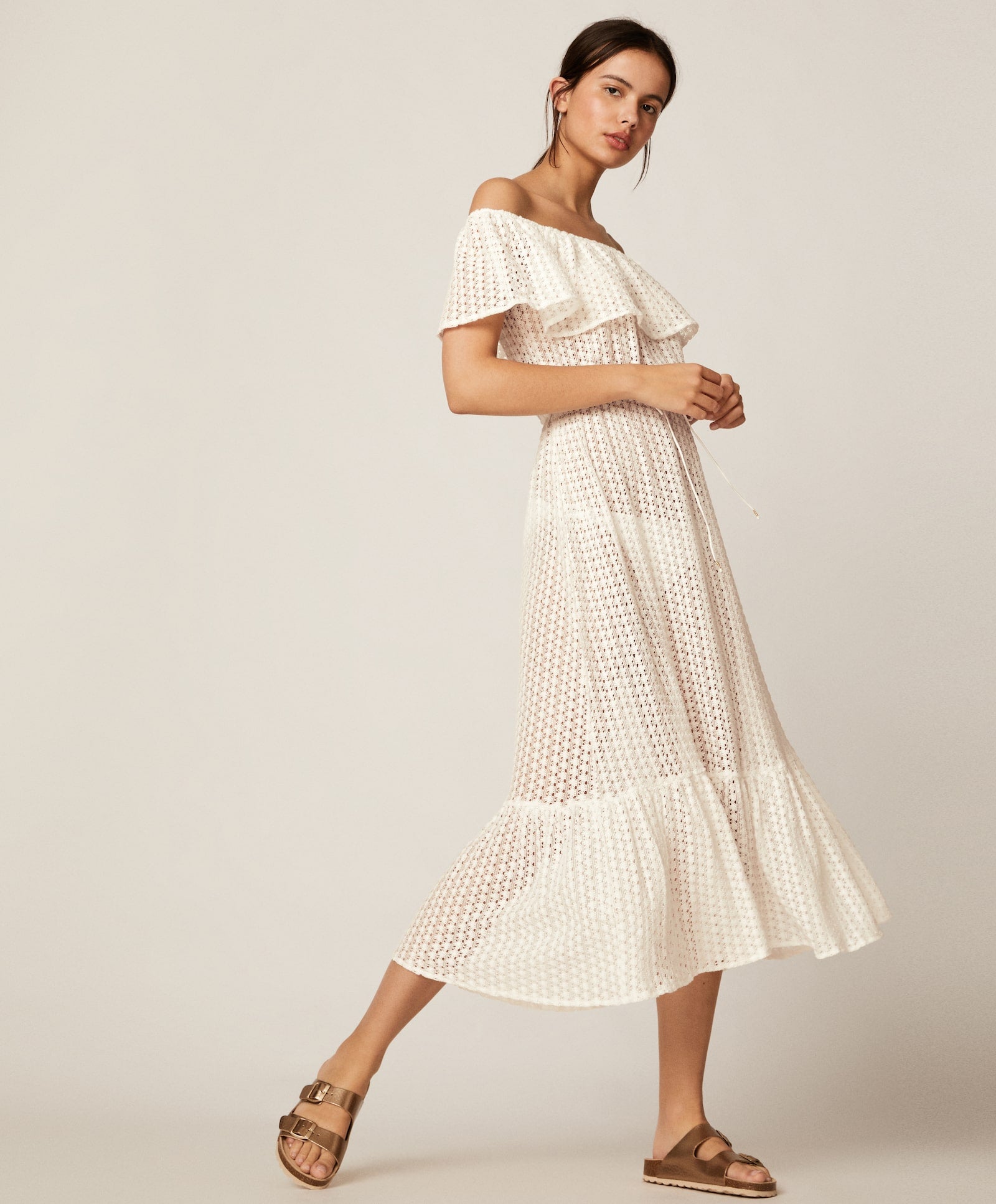 Vestido blanco calado de crochet con escote amplio y volantes para un look veraniego de 10. (29,99 euros).