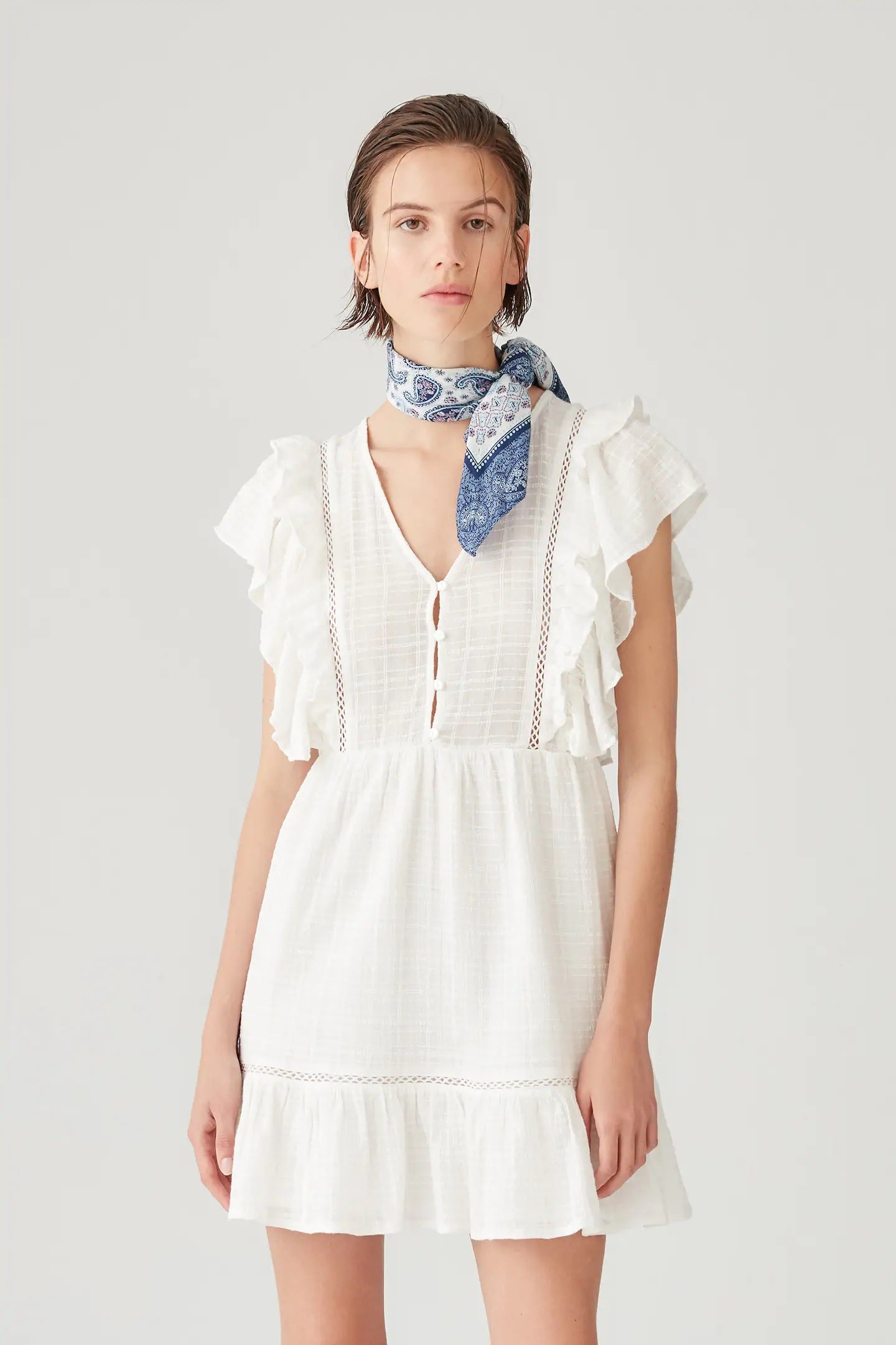 Minivestido blanco de Pull&Bear con volantes, botones y bordados. ¡Pura tendencia! (22,99 euros).