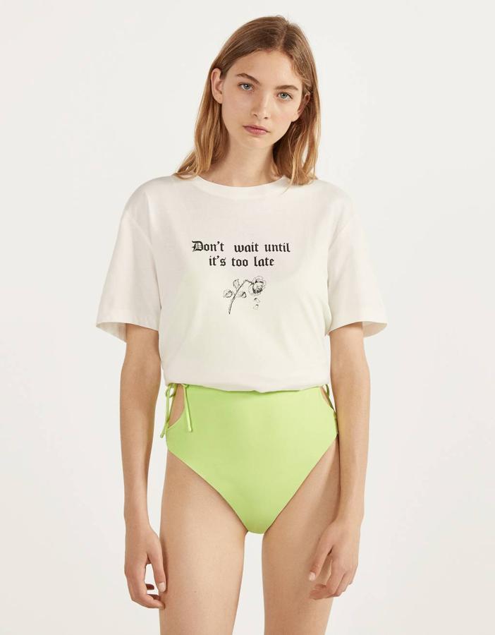 En blanco roto, con una rosa en el centro de la prenda y un contundente “no esperes hasta que sea demasiado tarde”, esta camiseta de Bershka  cuesta 7,99 euros  y está disponible entre las tallas XS y XL.