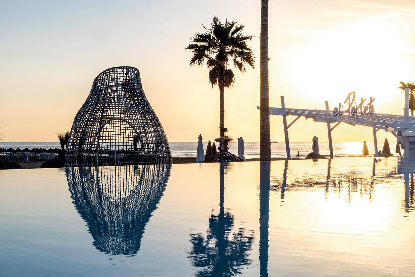 La que será Capital Mundial del Diseño en 2022 repone fuerzas en este híbrido entre resort balinés y exclusivo club de Saint-Tropez, situado en plena playa de la Marina. Por la mañana, podrás disfrutar del dolce far niente en las hamacas bajo sus sombrillas de paja; por la noche, sesiones de música en vivo. Y durante el resto del día, se puede elegir entre un restaurante de sello marinero (El Portet); otro cuyo fuerte son los arroces (Marina); y una fresca carta de fashion fast food (delicias japonesas, hamburguesas gourmet, sishas...) en la zona de la piscina. Aunque no hay límites de edad en los restaurantes, la zona de ocio está reservada a los mayores de 20 años.