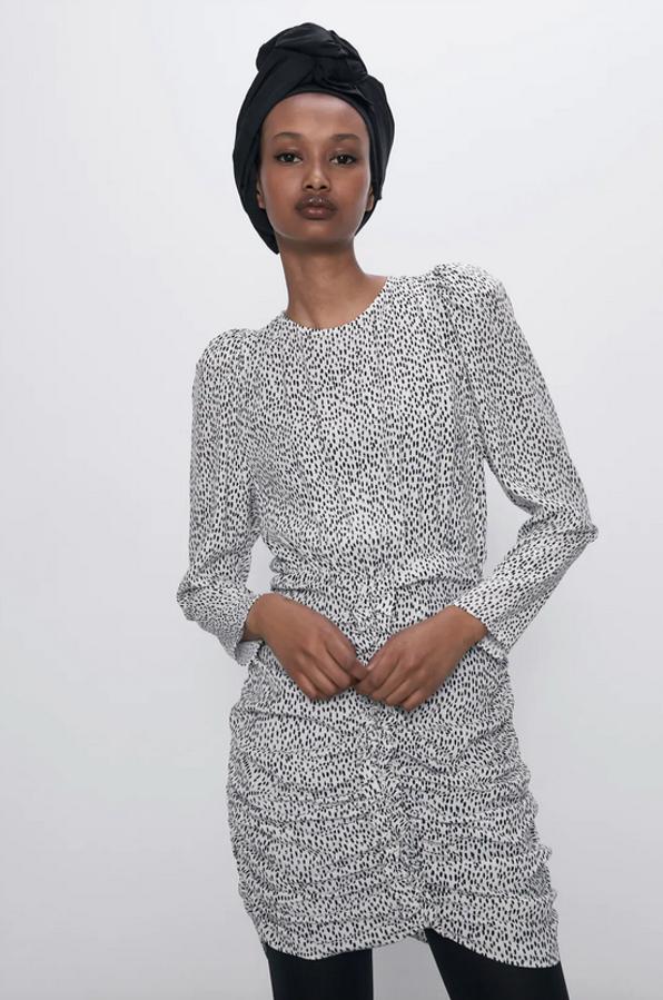 En color blanco con lunares en color negro, este vestido corto con cuello redondo tiene escote de pico en la espalda y lazada, además de las mangas largas abullonadas con los hombros marcados. De 29,95 euros ha pasado a costar 19,99 euros y está disponible entre las tallas XS y L.