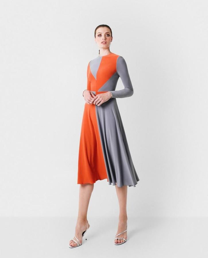 Vestido de invitada asimétrico en punto de seda bicolor con corte midi. Escote a la caja y manga larga. Sus cortes geométricos y bloques de color naranja y gris son una indudable propuesta colorida para cualquier ocasión. El toque final, su falda de vuelo que aporta una fluidez total al conjunto. Cosaba 235 euros y ahora te lo llevas por 164 euros.