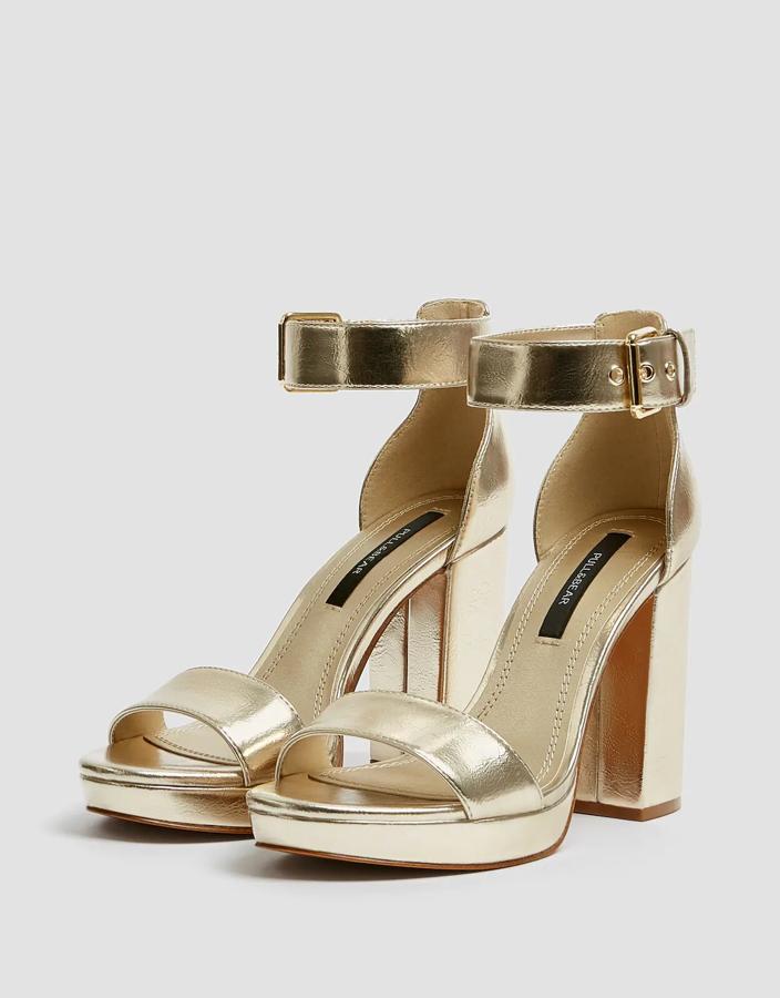 Estas sandalias en color dorado cuentan con un tacón de 9,5 centímetros y una plataforma de 1,5. Con tira en la parte delantera y cierre mediante hebilla lateral, son de Pull & Bear y tienen un precio de 19,99 euros.