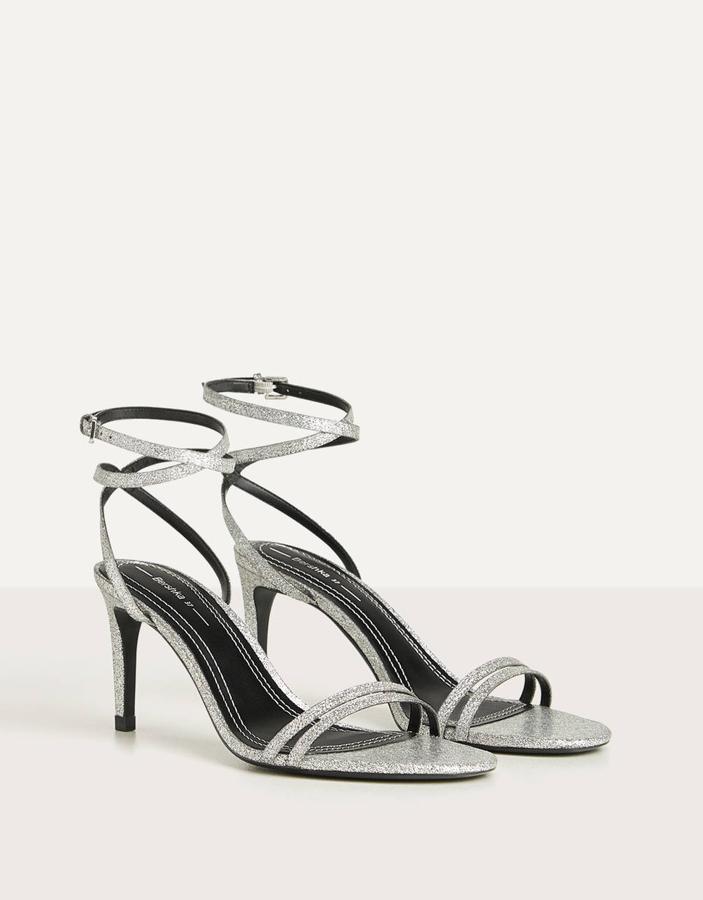 Con purpurina multicolor, esta sandalia con tacón y cierre mediante doble pulsera con hebilla es de Bershka y tiene un precio de 16,09 euros.