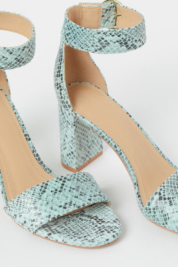 Con efecto piel de serpiente en color verde, esta sandalia con tacón revestido de 8 centímetros cuenta con pulsera ajustable con hebilla de metal y tiene un precio de 12,99 euros. Es de H&M.