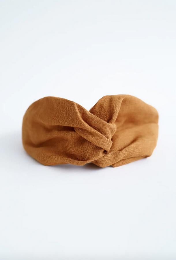 En lino color mostaza, con elástico en la parte inferior y nudo en la parte superior, esta diadema turbante de Zara cuesta 7,95 euros.