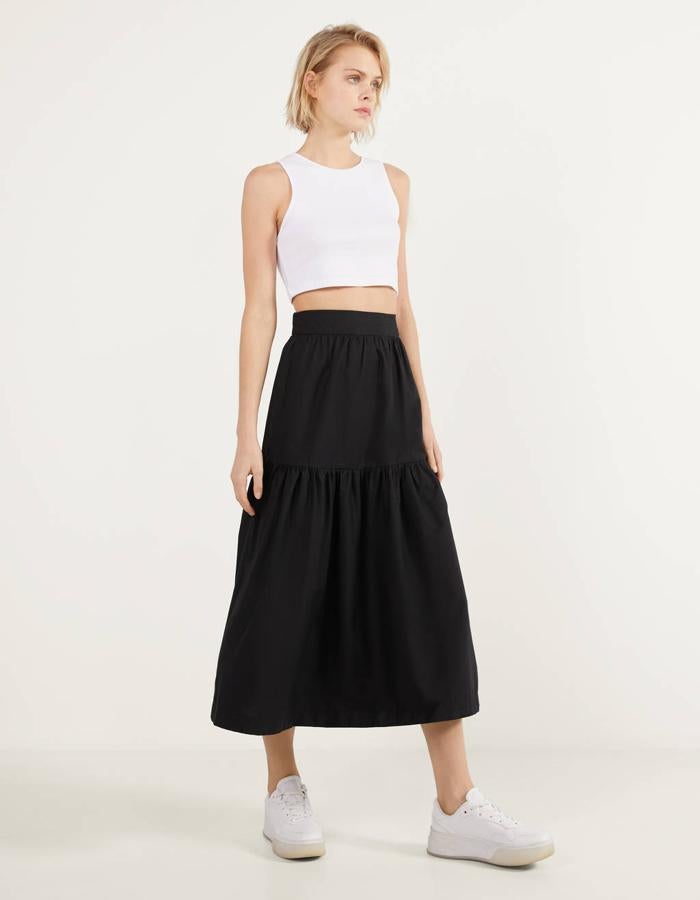 Diseño estructurado para esta falda negra de Bershka confeccionada en popelín. También está disponible en beige, y de 22,99 euros ha pasado a costar 12,99 euros. Está disponible entre las tallas S y XL.