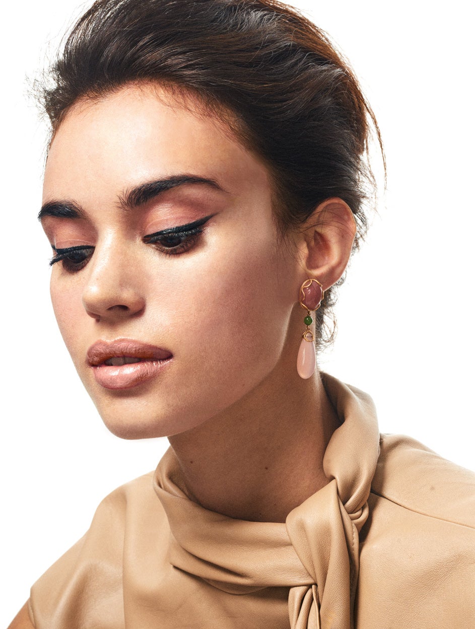 El eyeliner clásico transforma la mirada y vuelve con rotundidad. En la piel, unas gotas de Solar Glow Universal Illuminating Drops de Dolce & Gabbana Beauty. Top de piel con lazo, de Givenchy. Pendientes Venezia de Grassy.