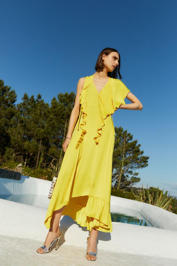 Vestido largo amarillo con volantes, con el bajo asimétrico, de la nueva colección de Sfera (59,99 euros).