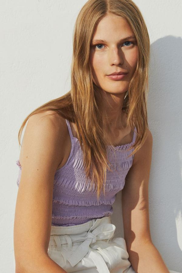 En punto suave de algodón, este top en lila claro viene con modelo entallado con tirantes finos y ribete de volantes sobrehilado en escote y bajo. Tiene un precio de 9,99 euros y llegará a la web próximamente en todas las tallas.