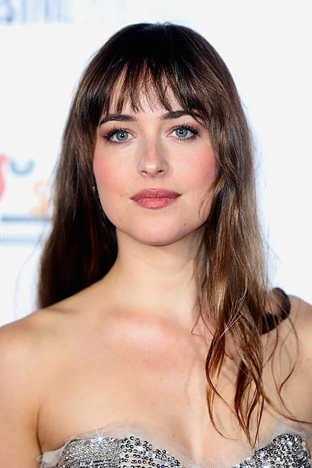 La versión sutil de las mechas rubias en una melena castaña es de Dakota Johnson.