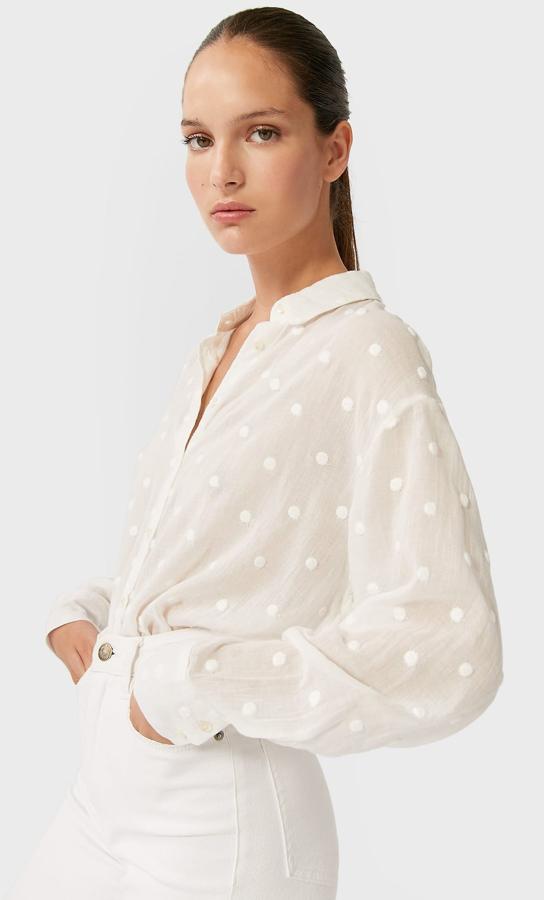 Camisa blanca de topos, rebajada de 17,99 a 9,99 euros.