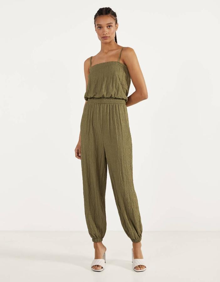 Diseño plisado y pantalón bombacho, para este mono largo de Bershka en color caqui con tirante fino y escote recto. Tiene la cintura ajustada por goma canilla y bajos elásticos y de 19,99 euros ha pasado a costar 11,99 euros. Está disponible entre las tallas XS y L, y también podemos encontrarlo en beige.
