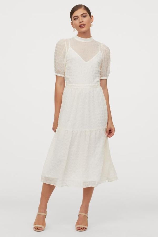 Este bonito vestido midi en color blanco está confeccionado en sircasa con tejido vaporoso estampado. Con costura en la cintura y falda con suave caída, tenía un precio de 39,99 euros y ahora podemos comprarlo por 27,99 euros únicamente en la talla 32. Y se está agotando.