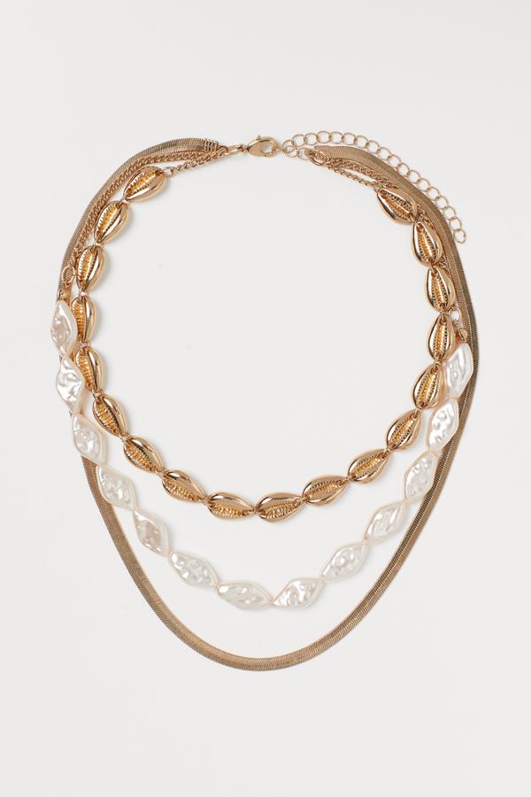 Collar de triple vuelta con cadena de malla metálica, cuentas de nácar y conchas doradas, de las rebajas de H&M (12,99 €).